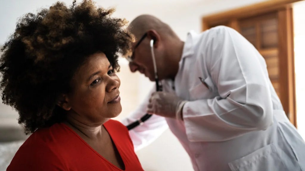 A doctor checking a woman for atrial fibrillation