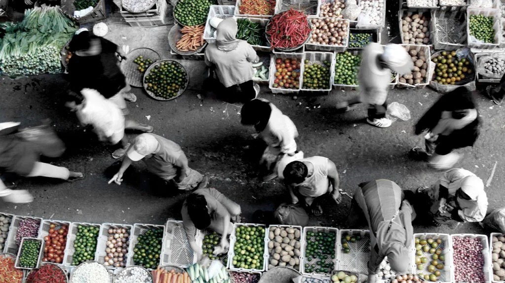 color pop photo of people walking through a fruit and veg market