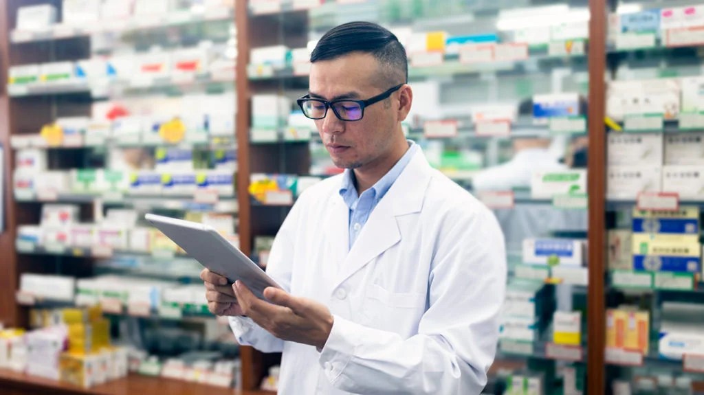 a pharmacist looking at a tablet computer